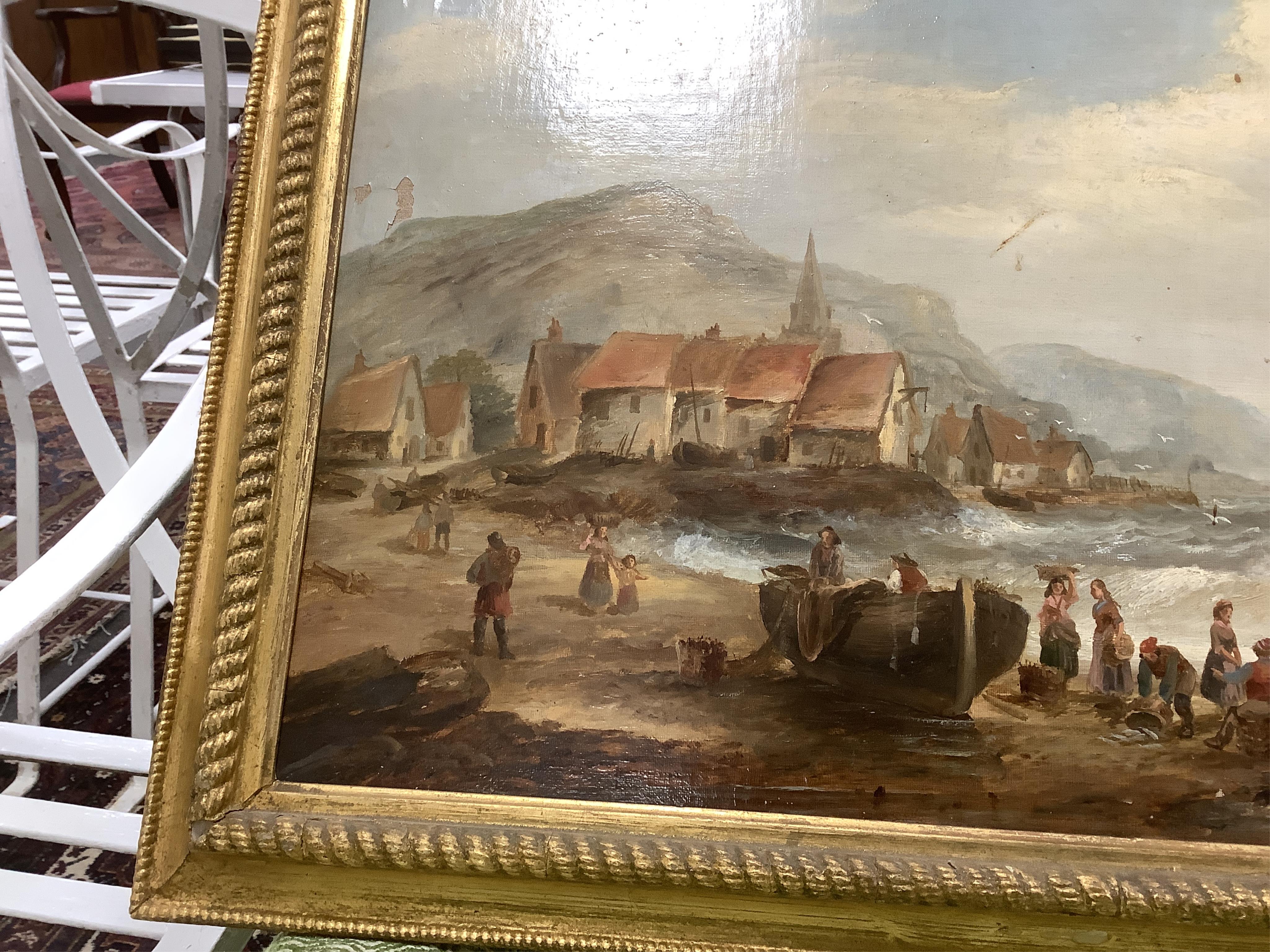 British School, 19th century, oil on canvas, Beach scene with figures, fishing boats, village and hills beyond, 37 x 67cm. Condition - fair, some losses to the paint
